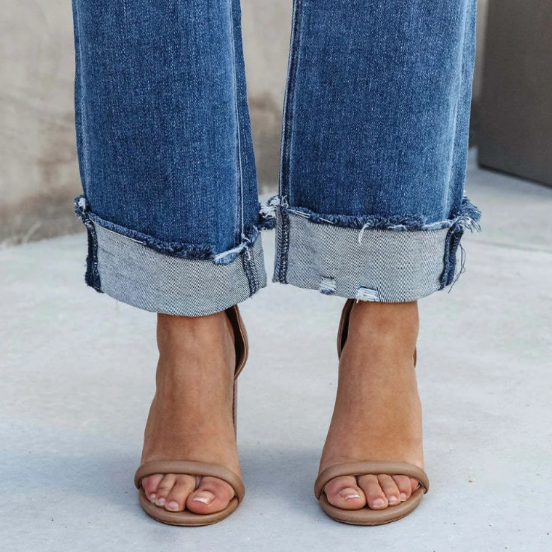 Close-up view of the rolled denim cuffs and footwear details