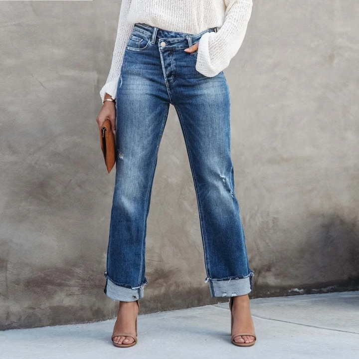 Front view of a woman wearing blue high-waisted relaxed fit jeans with rolled cuffs