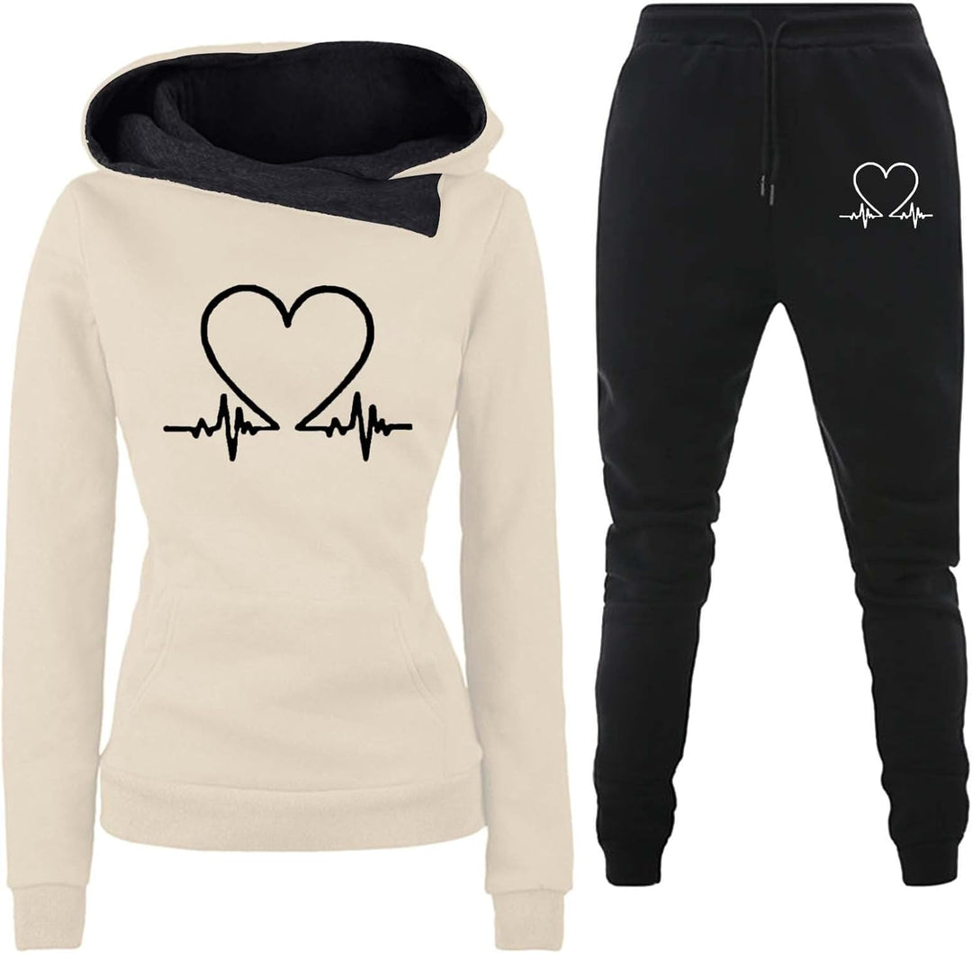 Beige hoodie with heart graphic displayed alongside black matching trousers.