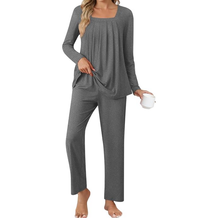Woman wearing grey long-sleeve lounge pyjama set holding a white mug