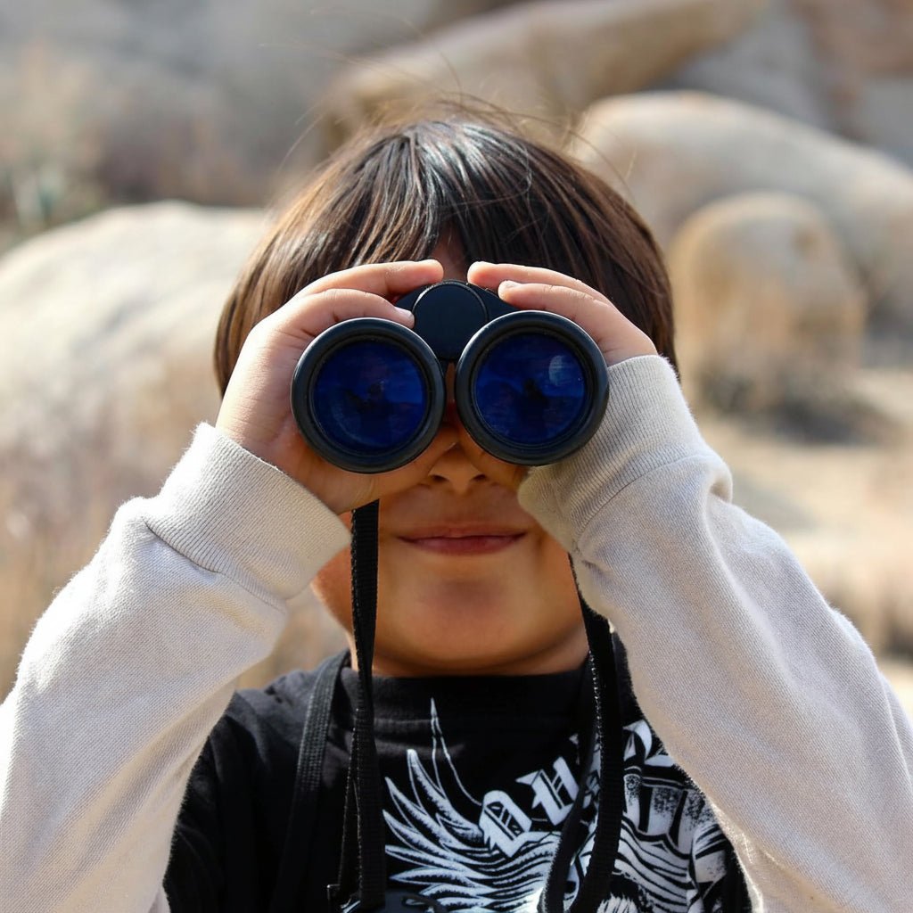 Compact 4x30 travel binoculars folded in hand for size comparison