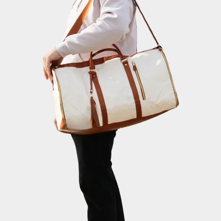 Model carrying the compact luxury carry on duffel bag comfortably over the shoulder