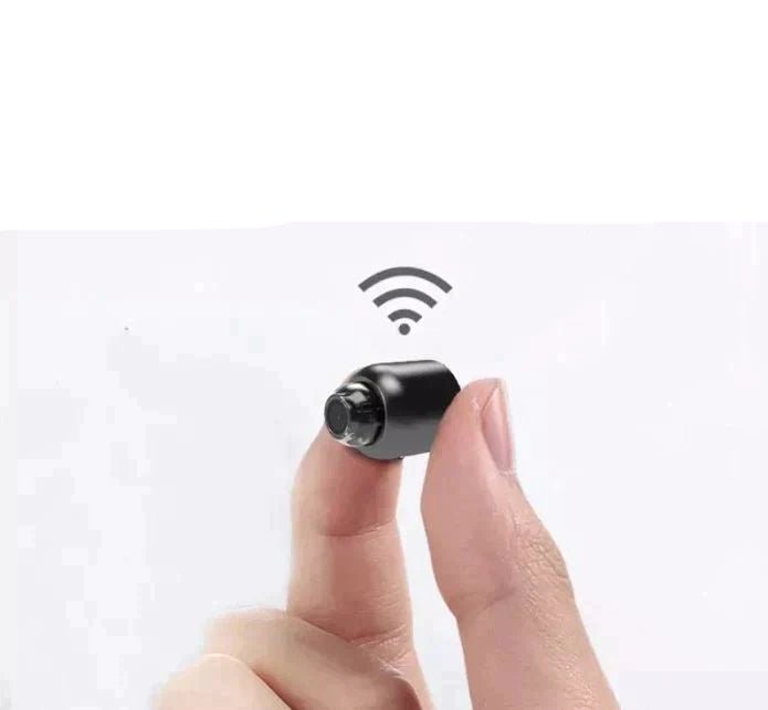 Mini wireless security camera held between fingers showing its compact size