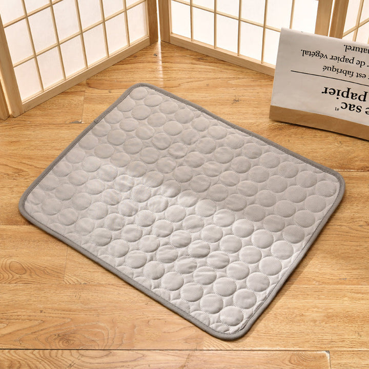 Light grey pet cooling mat laid on a wooden floor