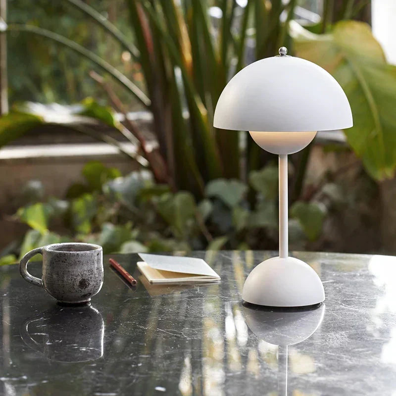 White cordless retro LED table lamp with umbrella design on a table next to a cup