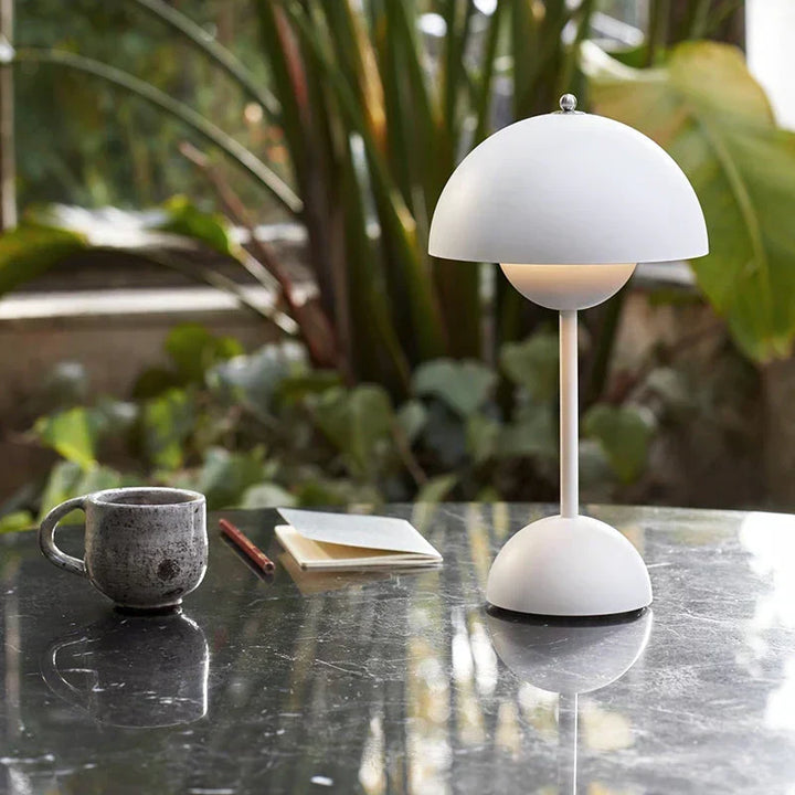 White cordless retro LED table lamp with umbrella design on a table next to a cup