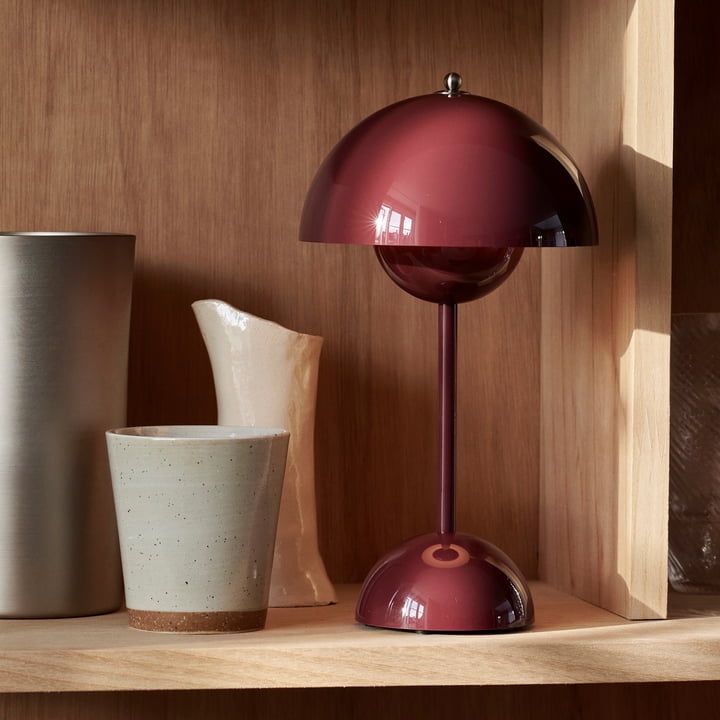 Red-brown cordless retro LED table lamp displayed on a wooden shelf next to vases