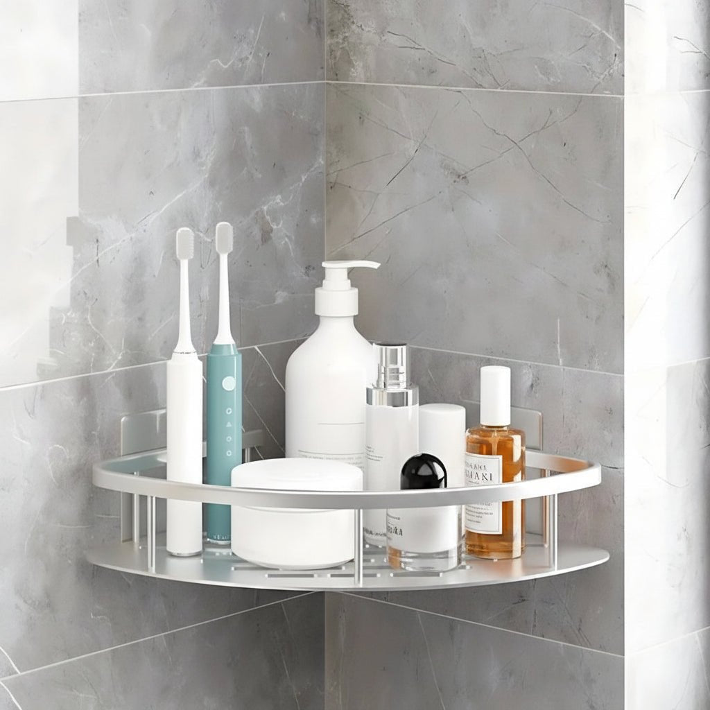 Silver single layer corner shower caddy holding toiletries and toothbrushes on a marble tile wall