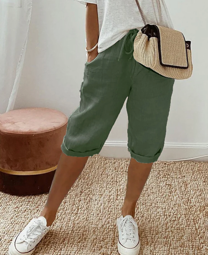 Woman wearing green casual drawstring shorts with white sneakers
