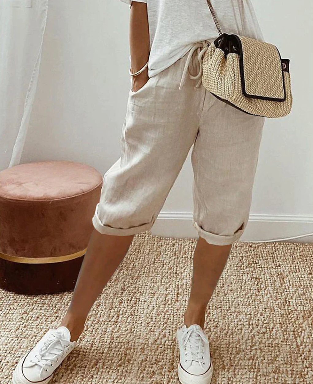 Woman wearing khaki casual drawstring shorts with white sneakers
