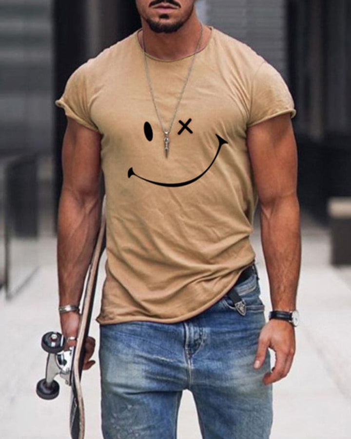 Man wearing a khaki short-sleeve t-shirt with a smiley face print