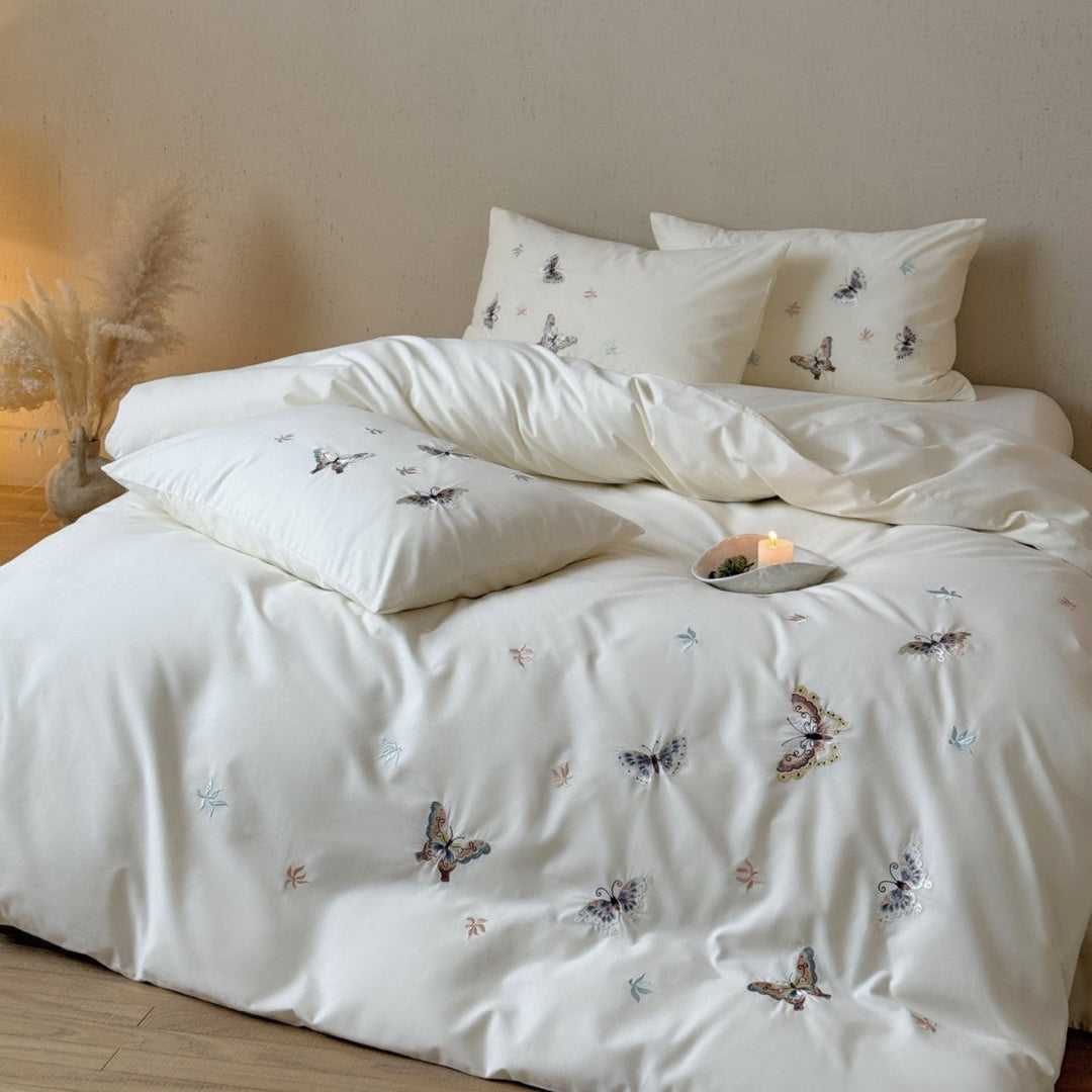 White cotton sateen bedding set featuring delicate butterfly embroidery on duvet and pillows