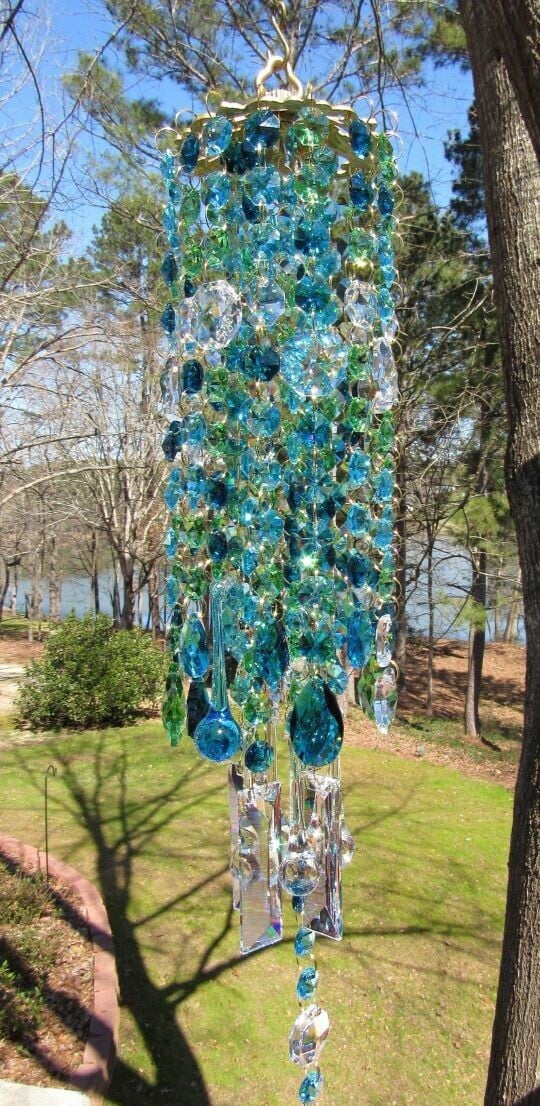 Blue crystal wind chime swaying gently in an outdoor landscape