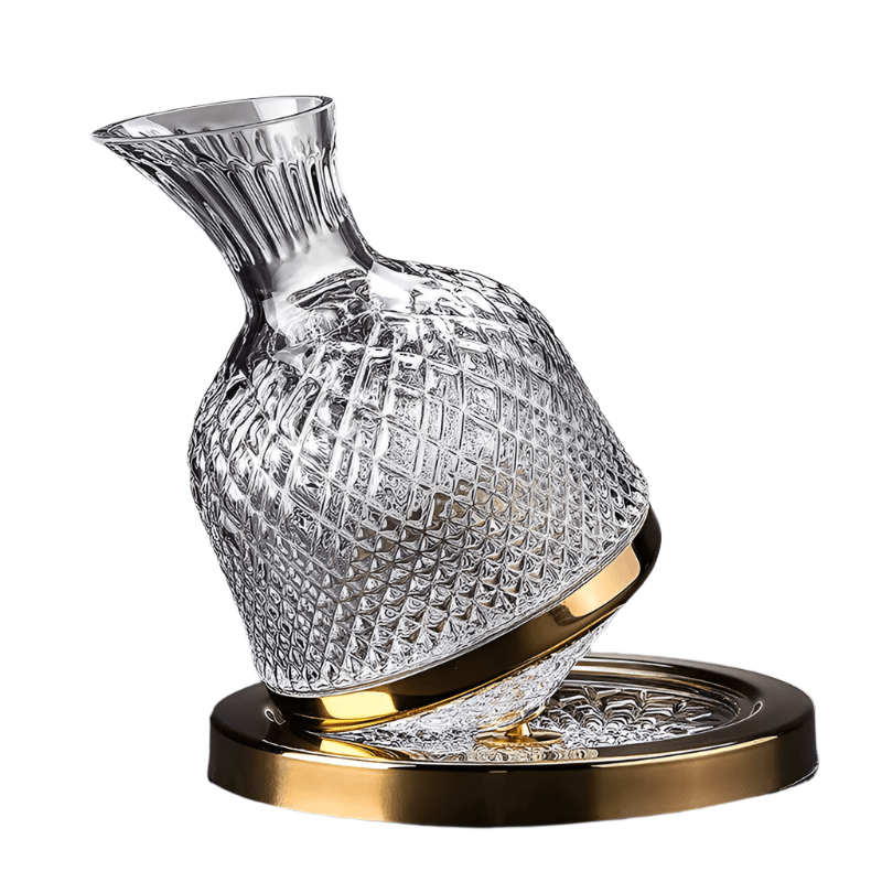 Crystal swivel wine decanter with gold base on a dark surface