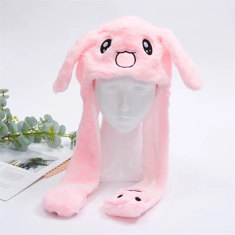 Pink rabbit plush moving ear hat displayed on a mannequin head