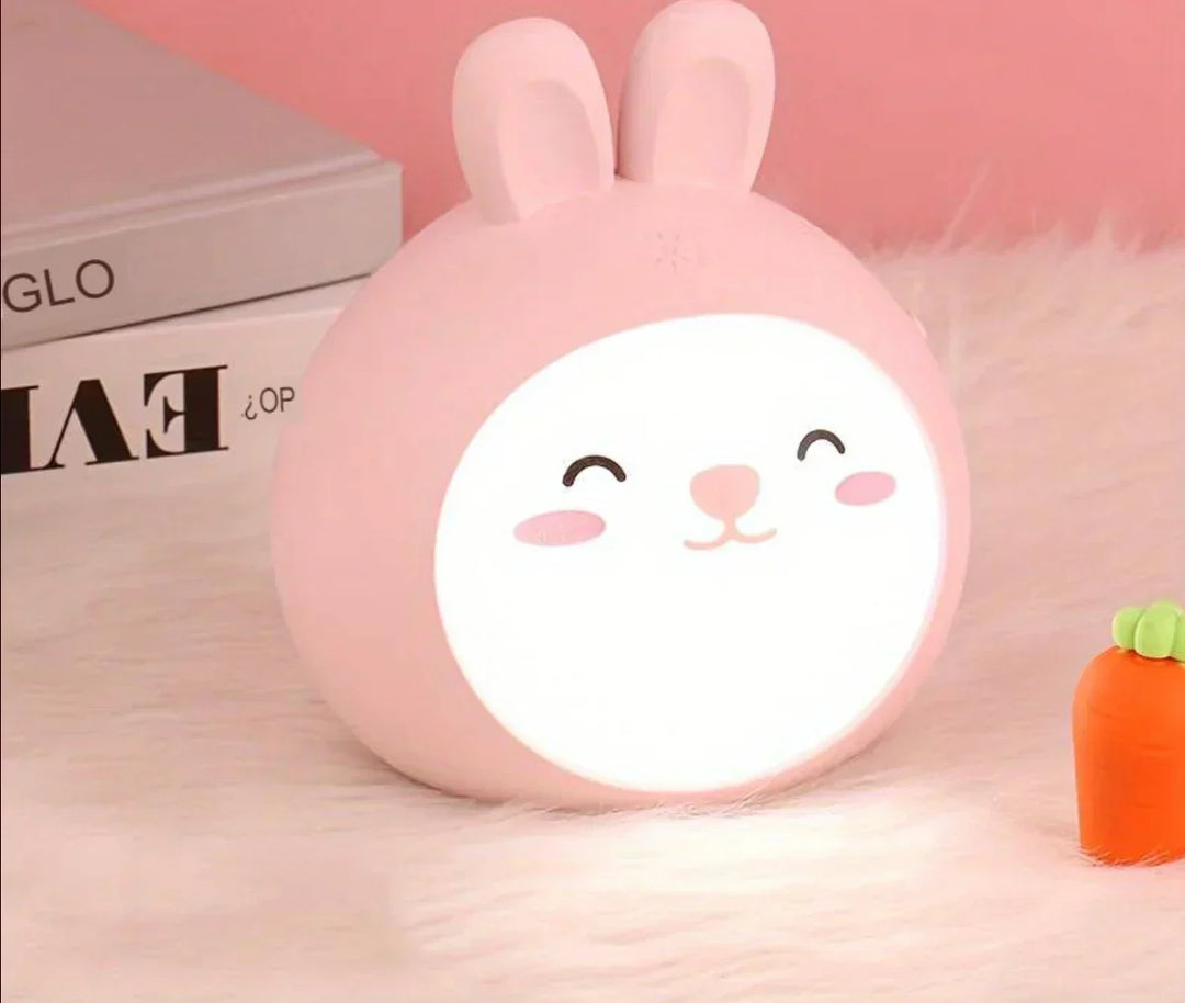 Cute yellow animal night light for children's room glowing on soft white faux fur