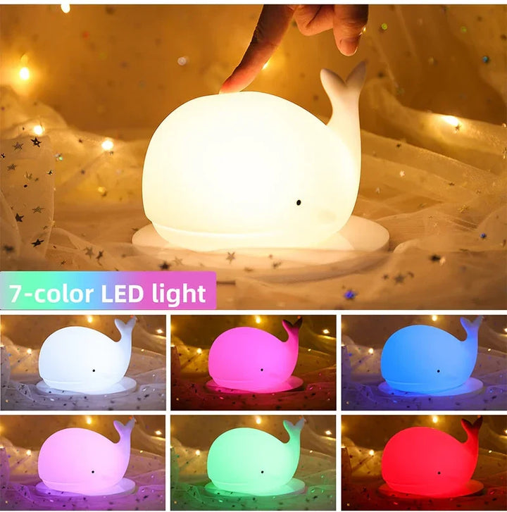 Hand demonstrating touch control and multiple colour options of the whale lamp