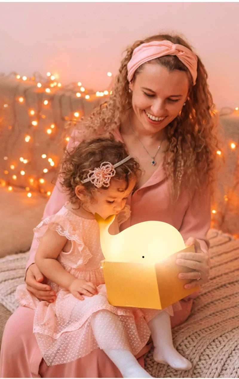 Cute whale colour changing night light glowing in a dark kids room