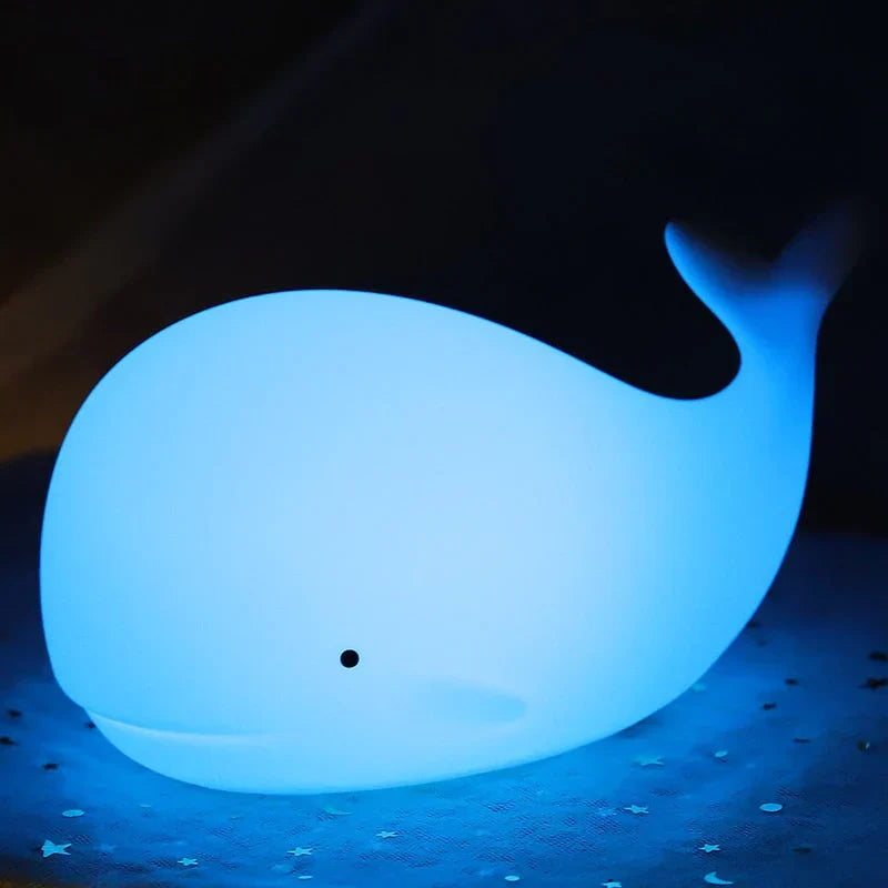 Bedside USB rechargeable whale night light on a childs wooden table