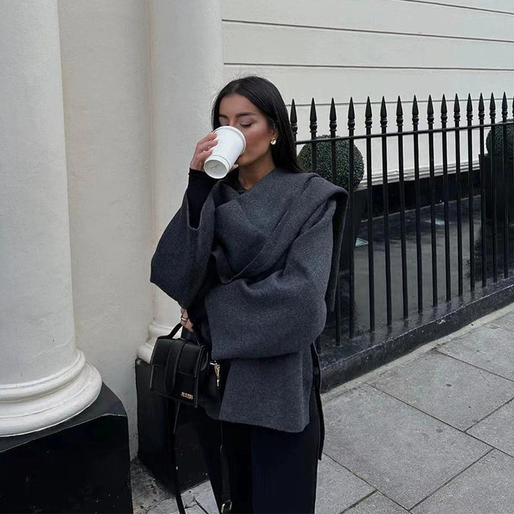 Close up profile of woman drinking coffee in dark grey wool coat