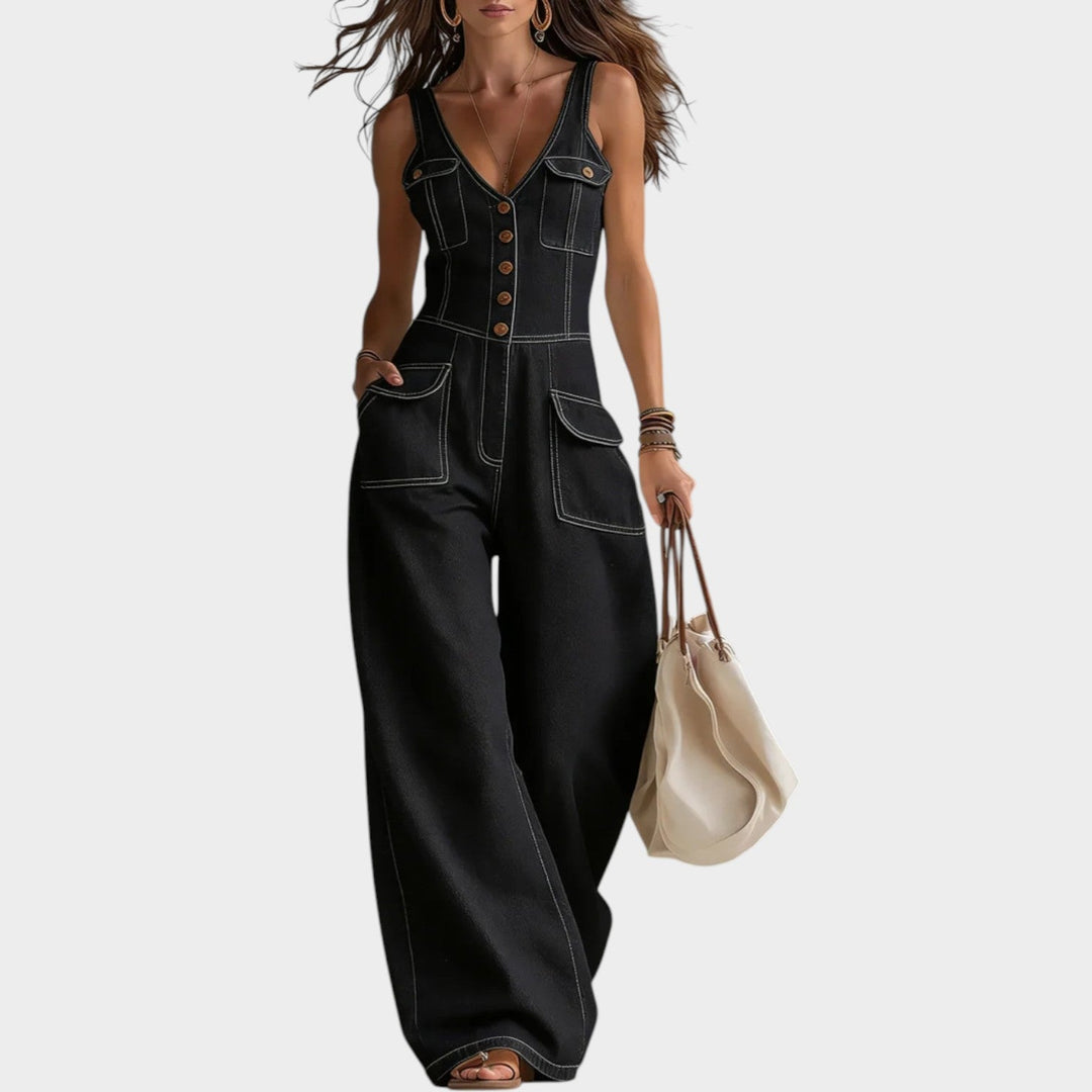 Model wearing black denim wide leg button-up jumpsuit with front buttons