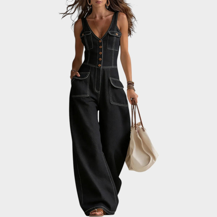 Model wearing black denim wide leg button-up jumpsuit with front buttons