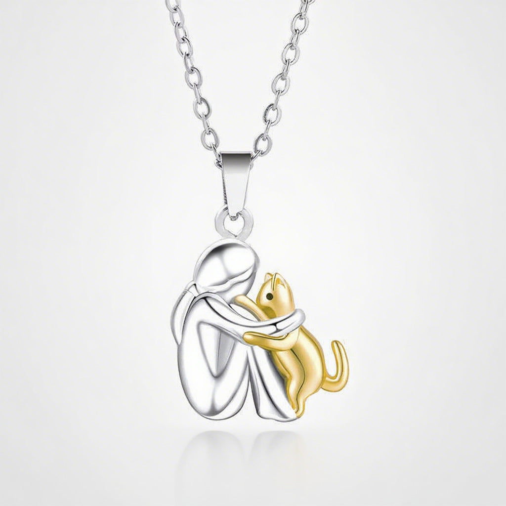 Women's silver and gold tone hug pendant necklace featuring a girl embracing a pet
