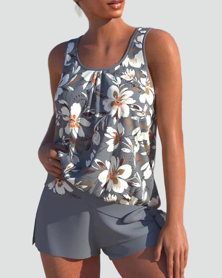Front view of a woman wearing the grey floral print tankini set with matching shorts