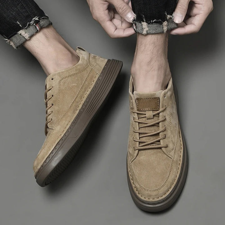 Top-down view of men's leather sneakers being laced up