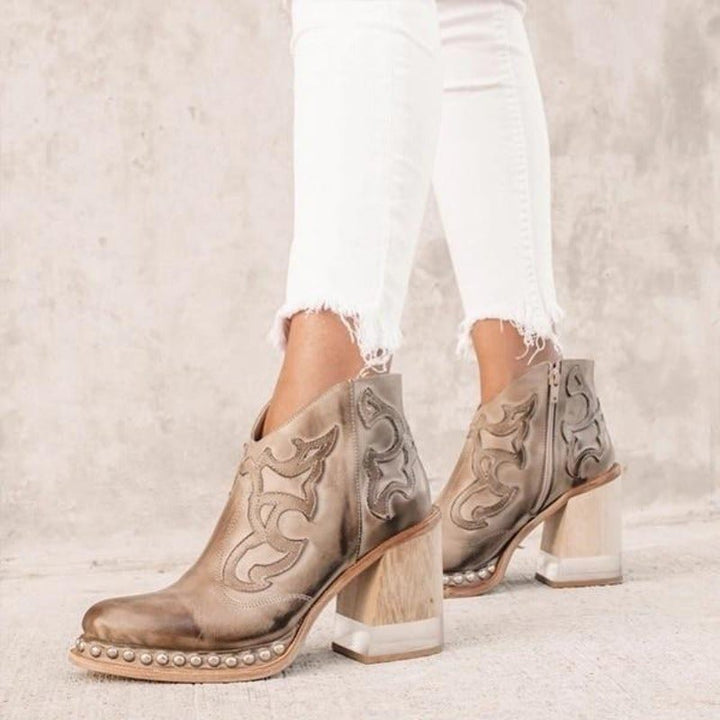 Low angle view of casual western ankle boots showing sturdy block heel and treaded sole