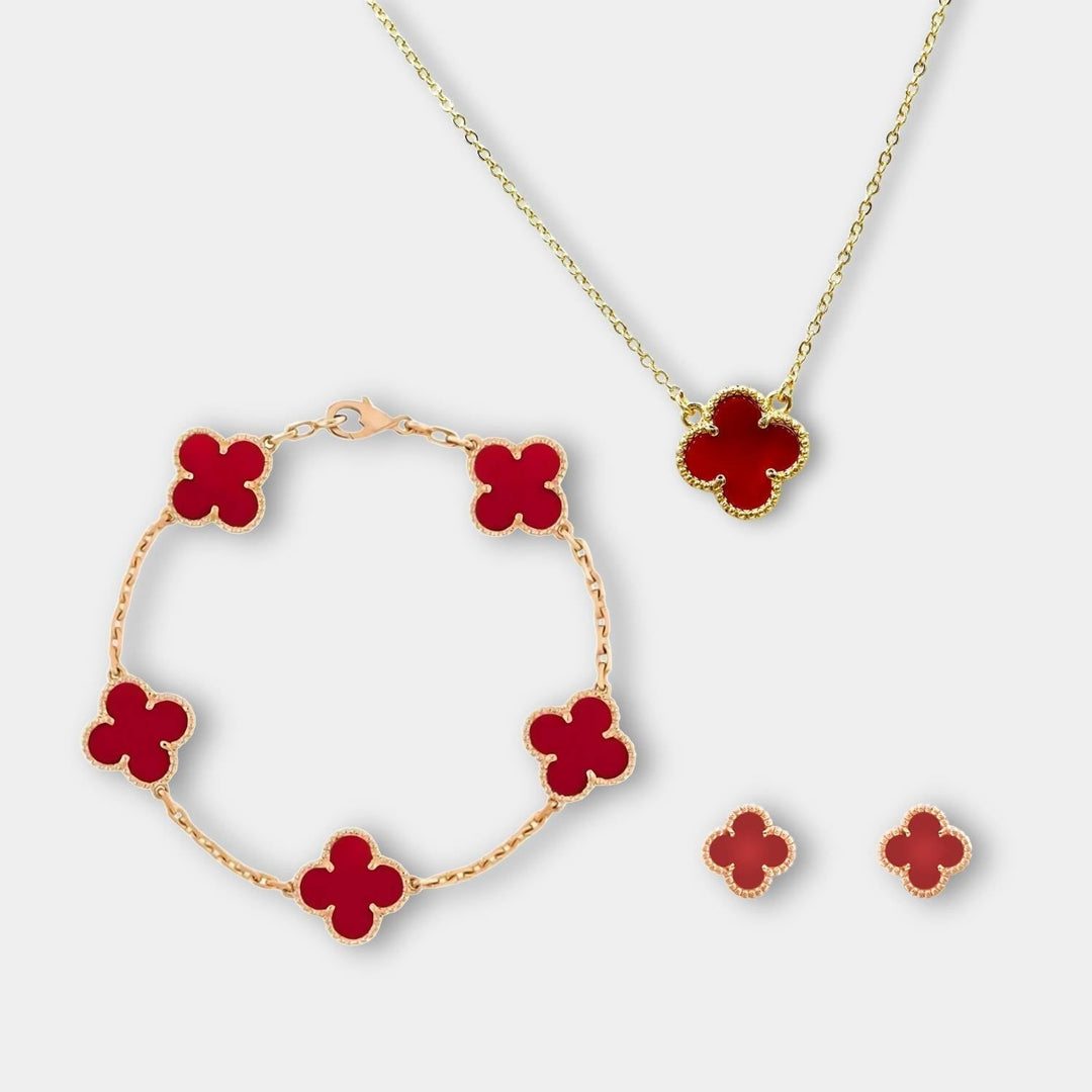 Flat lay of the red clover jewelry set including necklace, bracelet, and stud earrings