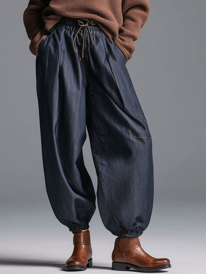 Model wearing dark navy blue lantern trousers with brown knit top and boots