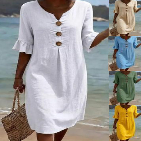 A collection of women's mini dresses displayed in multiple vibrant color options near a beach.