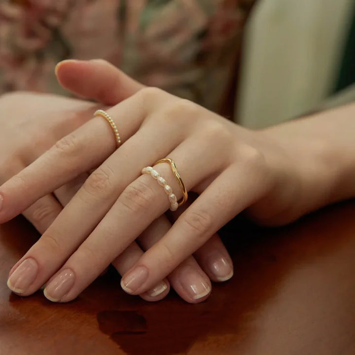 Womens double layered gold ring featuring a delicate freshwater pearl in a stylish design