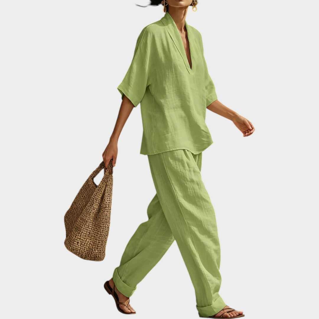 Side view of a woman walking in the green matching top and wide-leg trousers set.