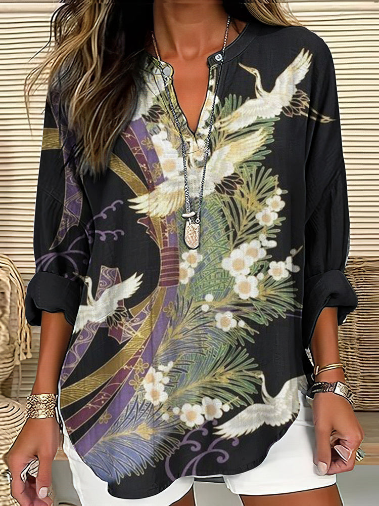 Close-up view of the printed motif and V-neckline on the black blouse