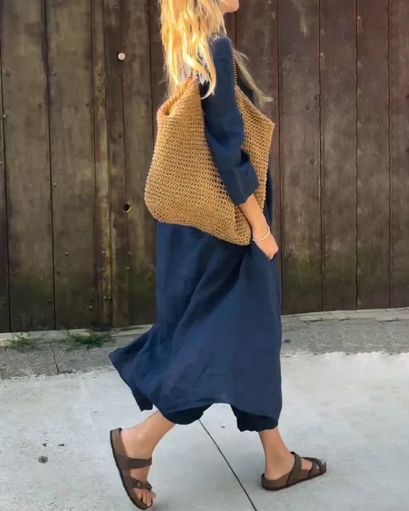 Side view of a woman walking in a comfortable dark blue matching top and trousers set