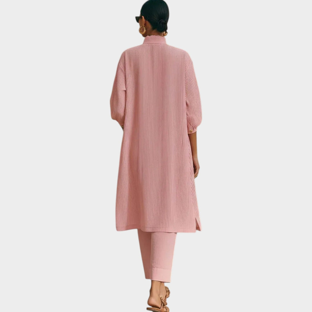 Back view of a woman showcasing the relaxed fit of the pink matching two-piece clothing set.