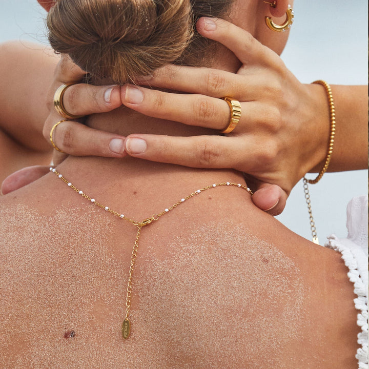 Trendy women's jewelry piece: white enamel and gold bead choker