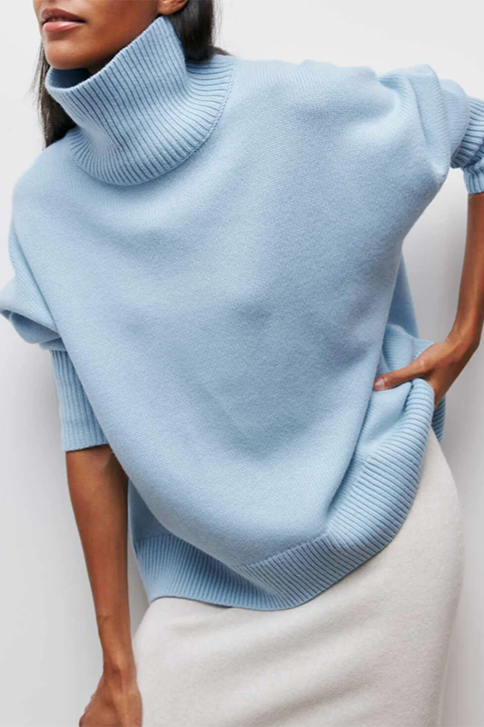 Model wearing a light blue oversized turtleneck sweater in a stylish pose