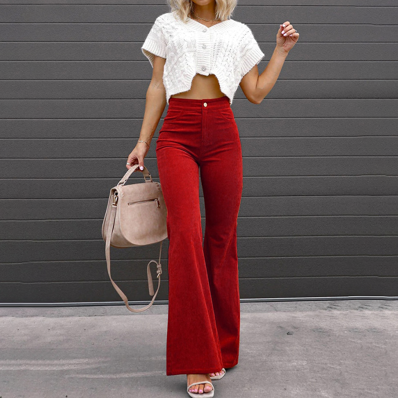 Model wearing red high-waisted flared trousers with a white top and handbag