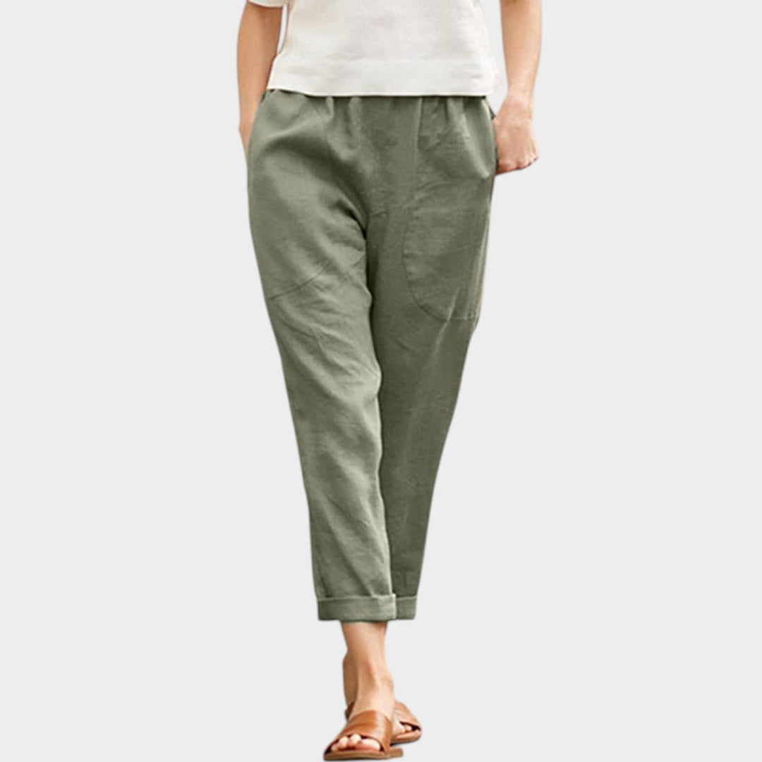 Woman wearing green casual trousers with a white top