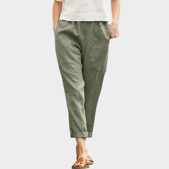 Woman wearing green casual trousers with a white top