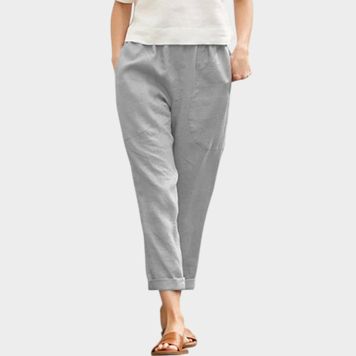 Woman wearing grey casual trousers with a white top