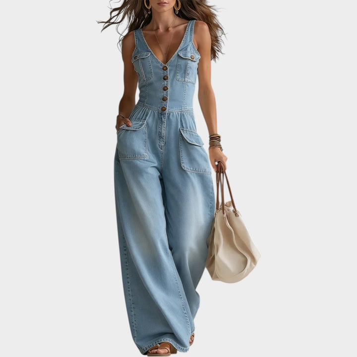 Model wearing light blue denim wide leg button-up jumpsuit outdoors