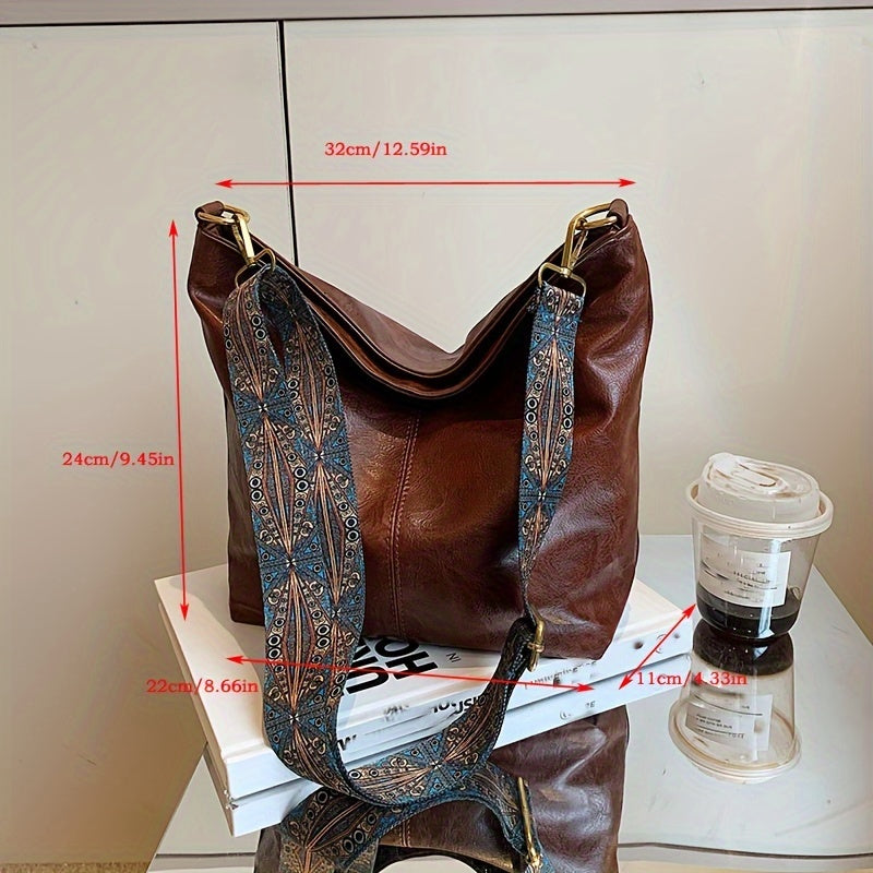 Close-up of the zipper pull and reinforced seams on the shoulder bag