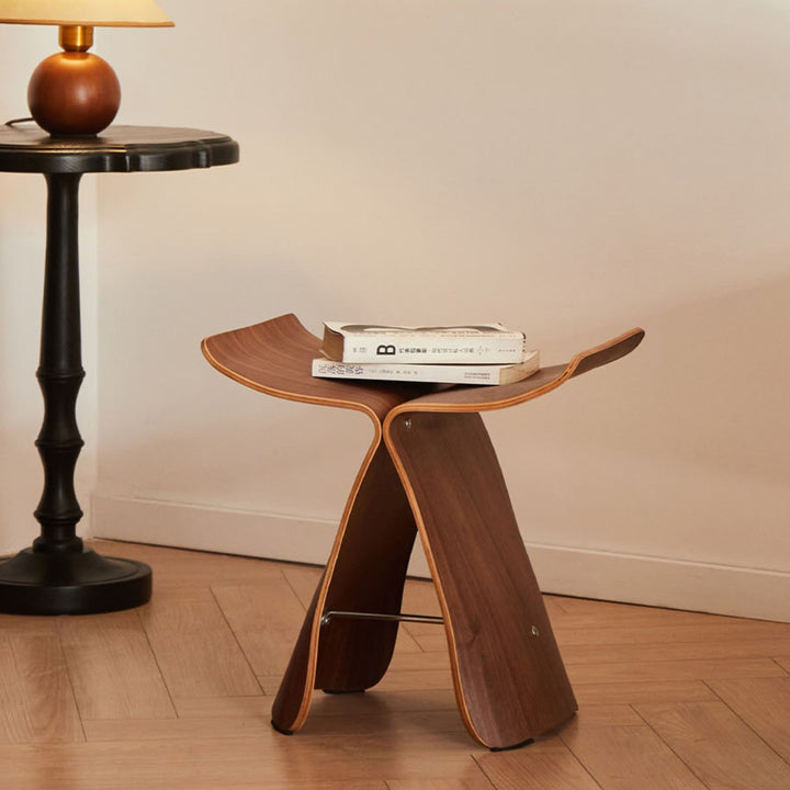 Wooden butterfly stool styled in a living room with books on top