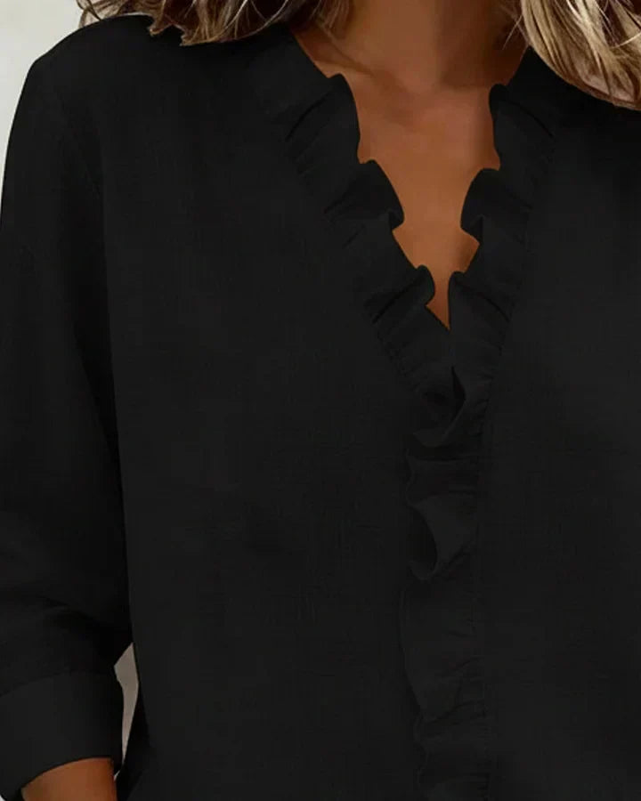 Close-up of v-neckline and ruffled trim on womens top