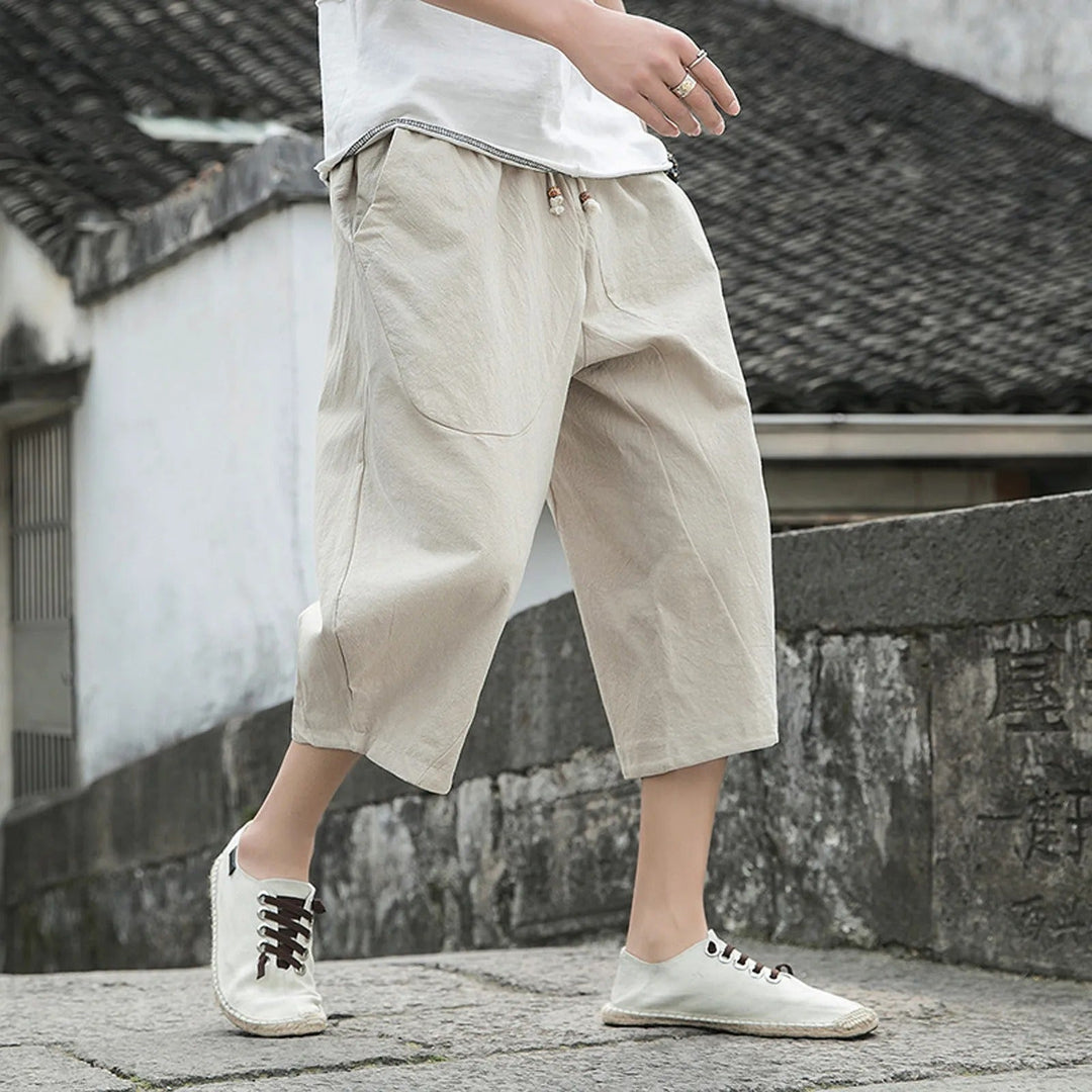 Man wearing beige casual three-quarter trousers on stone steps