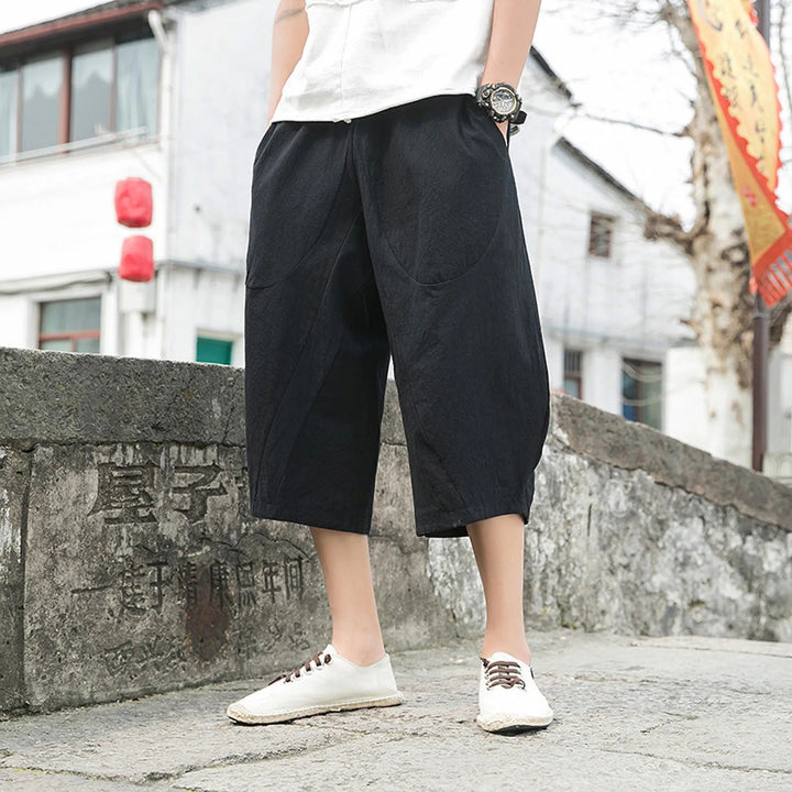 Man wearing black casual three-quarter trousers with white shoes